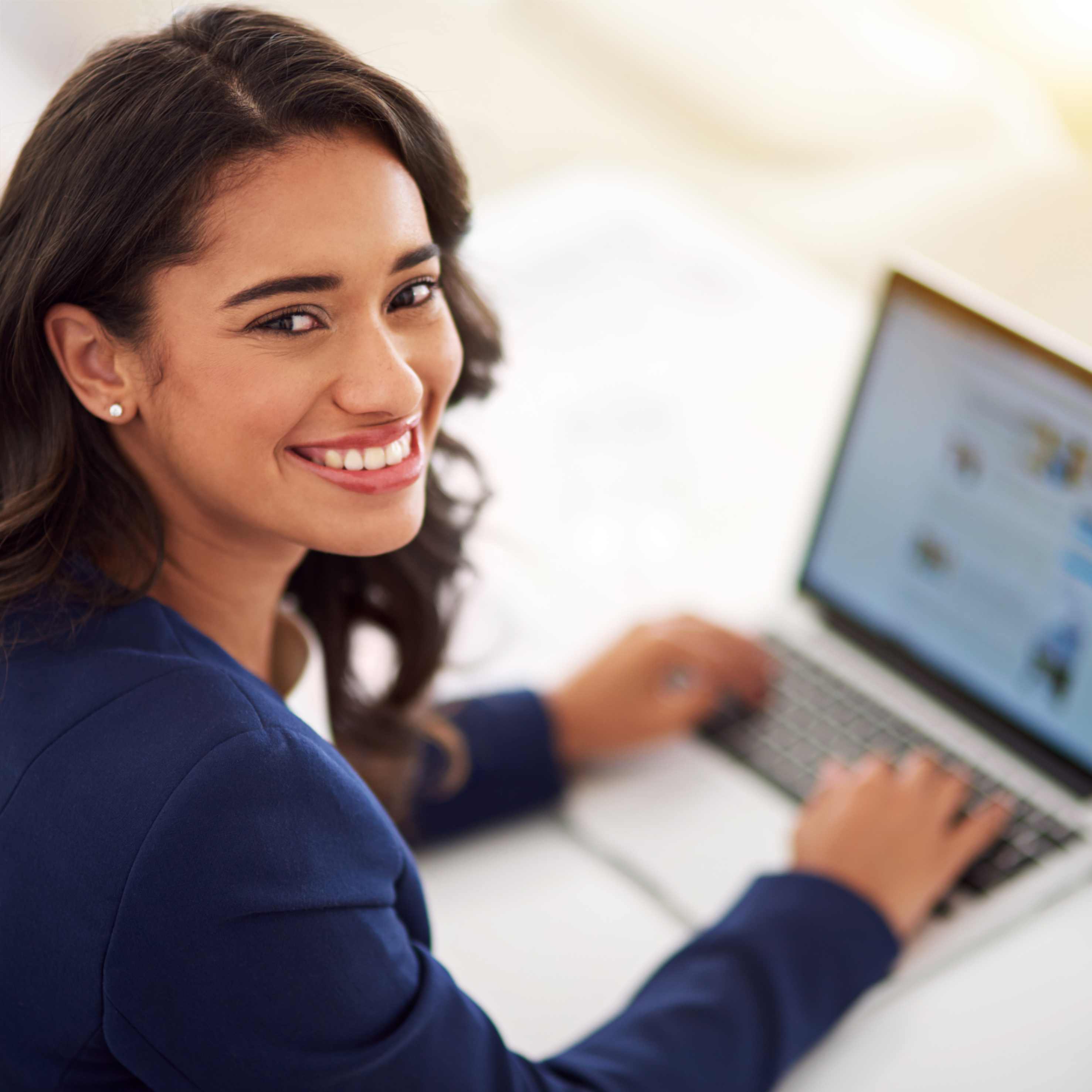 Smiling girl working on a laptop